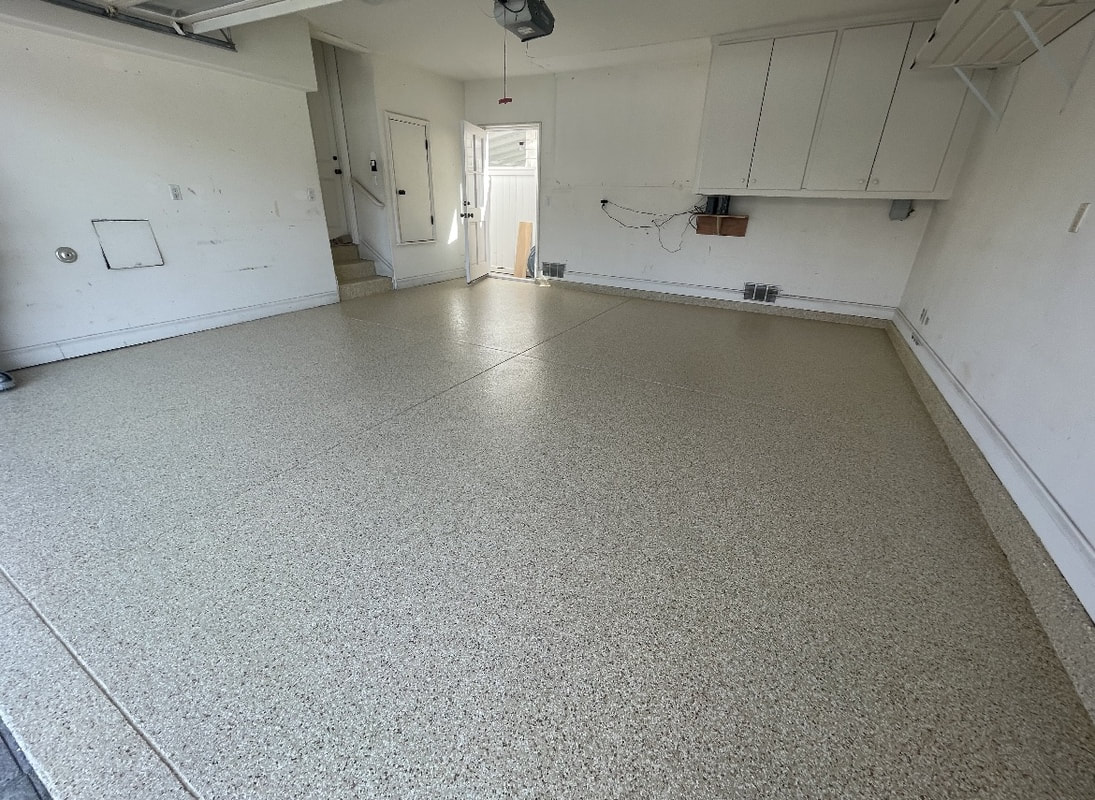 Garage with a light tan and white epoxy flake floor
